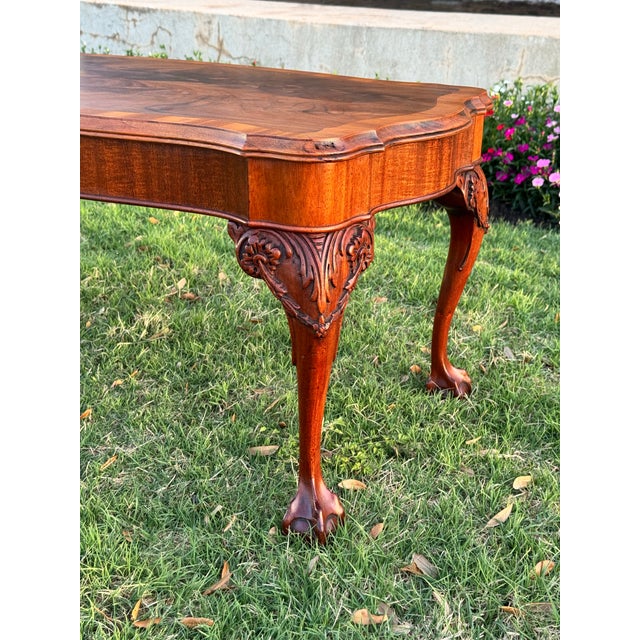 Antique Chippendale Style wooden coffee table, characterized by ornate carved cabriole legs ending in ball-and-claw feet...