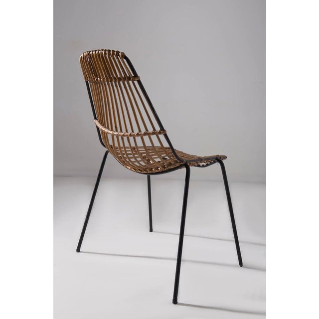This pair of rattan chairs is a refined example of light and functional design, typical of the 1950s and 60s, where the...