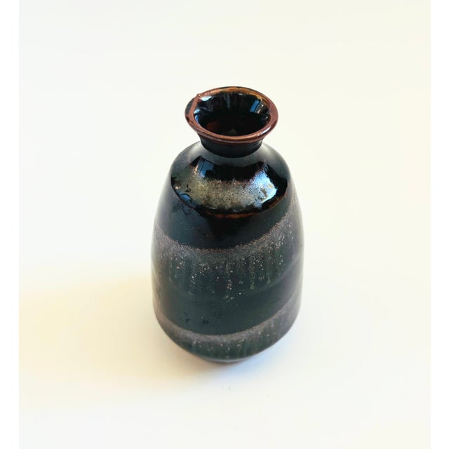 A small vintage ceramic bud vase. Dark glazes with a spiral design wrapping around the sides. Nice tapered shape. Original...
