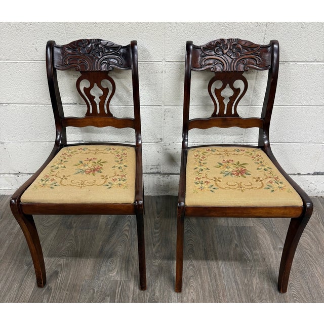 This is a pair of vintage Duncan Phyfe Regency style mahogany dining chairs featuring pierced Chippendale-style splat...