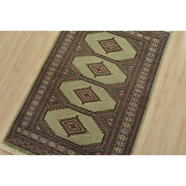 A tribal Bokhara Jaldar rug hand-knotted with fine wool on a cotton foundation. This rug features geometric medallions set...