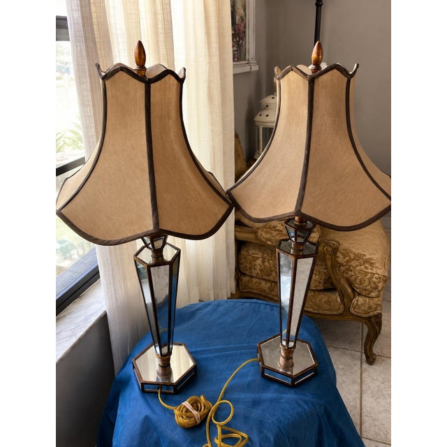 Beautiful pair of decorative table lamps featuring elegant faceted mirrored-glass bases with dark or metal trim and warm...