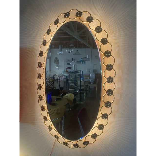 Elegant large wall-mounted mirror, regency style, made in the 1970s. Light being emitted from 6 points behind the mirror,...