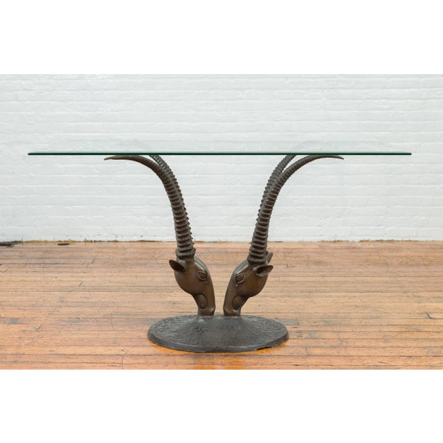 A contemporary bronze double antelope dining table base, top not included. Created with the traditional technique of the...