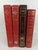 Striking collection of four decorative hardcover volumes in rich shades of red and burgundy, unified by elaborate gold and...