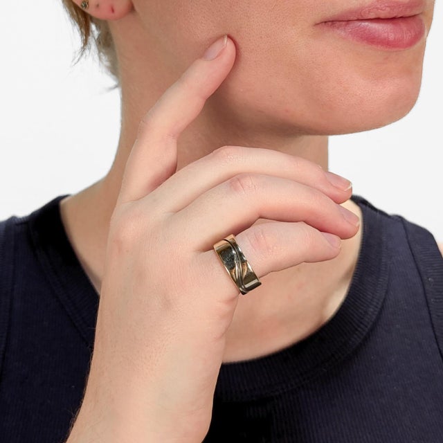 A fine signed Mid-Century Modern cigar band ring. In mixed metals. With a sterling silver base and thick band of 14k...