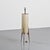 "Rocket" floor lamp produced circa 1960. The lamp features a cylindrical shade made of woven vegetal fibers, fitted within...