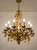 Florentine-style floral chandelier made in Italy in the 1950s and 1960s, featuring a wrought iron structure with a gold...