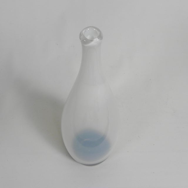 Mid-century vase with an organic teardrop or bottle shape, where white glass transitions into a thick purple-brown base....