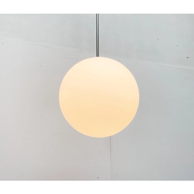 Simple glass ball pendant lamp from the renowned house of Glashütte Limburg. Classic tubular pendant with ball in an...