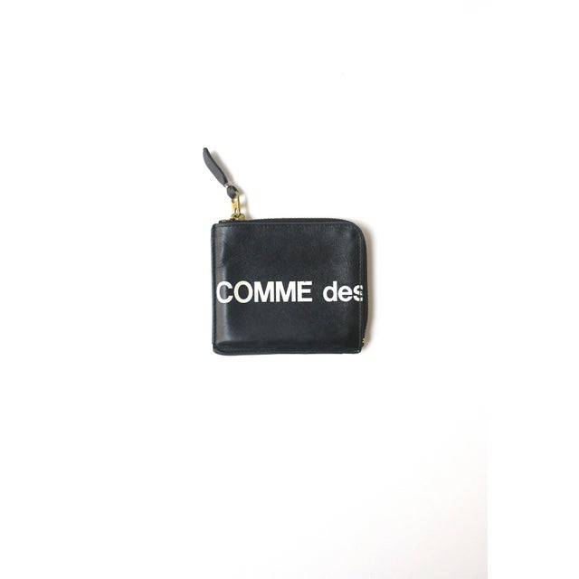 A chic Comme des Garçons black and white leather wallet with brass zipper, crafted in Spain, circa late 1990s to early...
