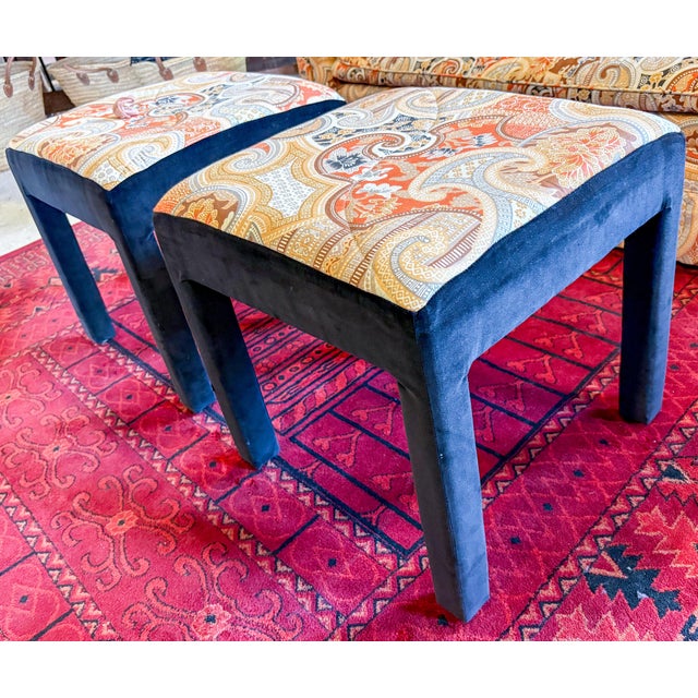 Charming pair of matching foot stools or ottomans upholstered in an orange print on the top and black velvet legs. Fabric...