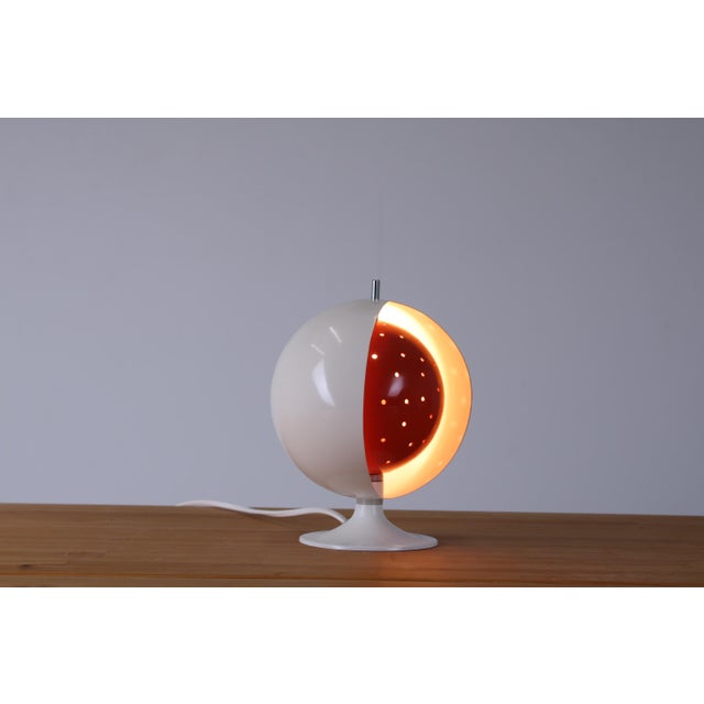 Fantastic sixties anvia eclisse eyeball metal table light. a white metal globe is covering an inner half globe shade that...