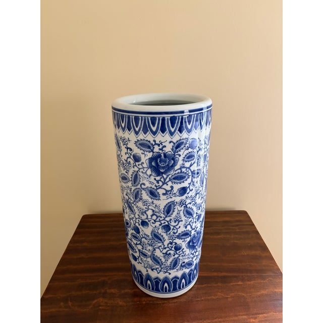 A classic blue and white porcelain umbrella stand in the chinoiserie tradition, featuring Asian floral designs. The crisp...