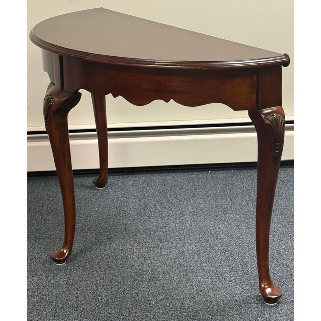 Beautiful Georgian style Demi lune table by Kincaid. Features prominent carved shell motifs on the knee of each leg,...