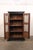 A tall British Colonial two-door storage cabinet from the early 20th century. This antique Anglo-Indian British Colonial...
