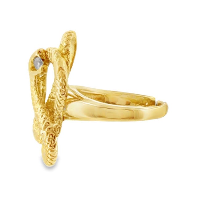 Vintage 18K gold statement ring, featuring an intricate coiling snake design in yellow gold. The snake's head is adorned...