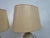 A sculptural pair of mid-century table lamps executed in carved travertine, circa 1970s. Each lamp features a solid,...