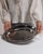 This early 20th century tray from France is finished in gray, worked in silver. Its form follows honest, well-proportioned...