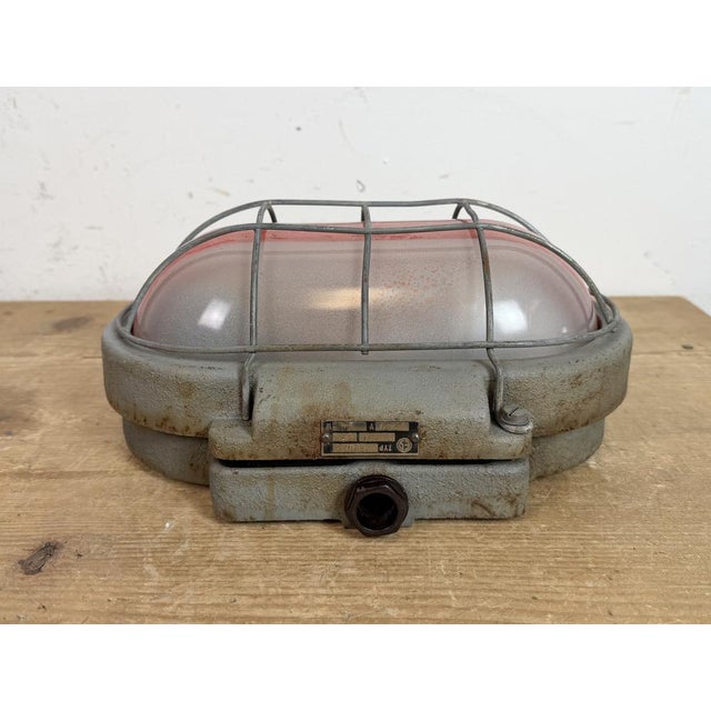 Industrial wall light made by Elektrosvit in former Czechoslovakia during the 1960s. It features a cast iron body, a milk...