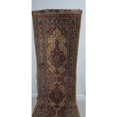 A very good tribal oriental runner, deep red, blue and gold wool, in very good overall condition. 129" x 34"Y