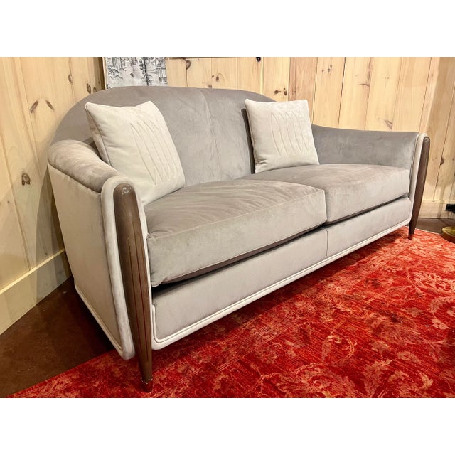 A beautiful Theodore Alexander Curved Tight back sofa done in a gray velvet fabric with leather trim along the farm and...