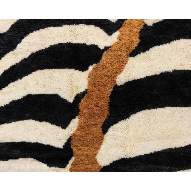 Op art meets gold leaf: hypnotic stripes, split by a single river of ochre. Bold charcoal black and ivory stripes sweep...