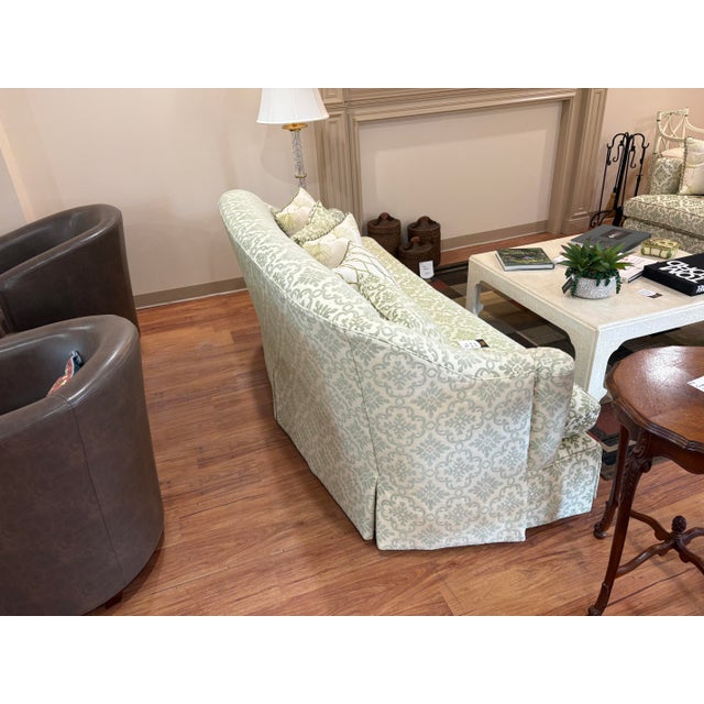 A refined matching pair of Kravet sofas upholstered in a soft sage green geometric damask on a cream ground. Each piece...
