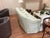 A refined matching pair of Kravet sofas upholstered in a soft sage green geometric damask on a cream ground. Each piece...