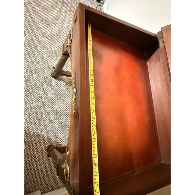 This antique French Empire style writing table , typically made of mahogany and adorned with gilt-bronze or brass mounts....