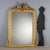 Eclectic freestanding mirror in carved and gilded fir. Frame with leaf carvings and internal beading, fretworked frieze...