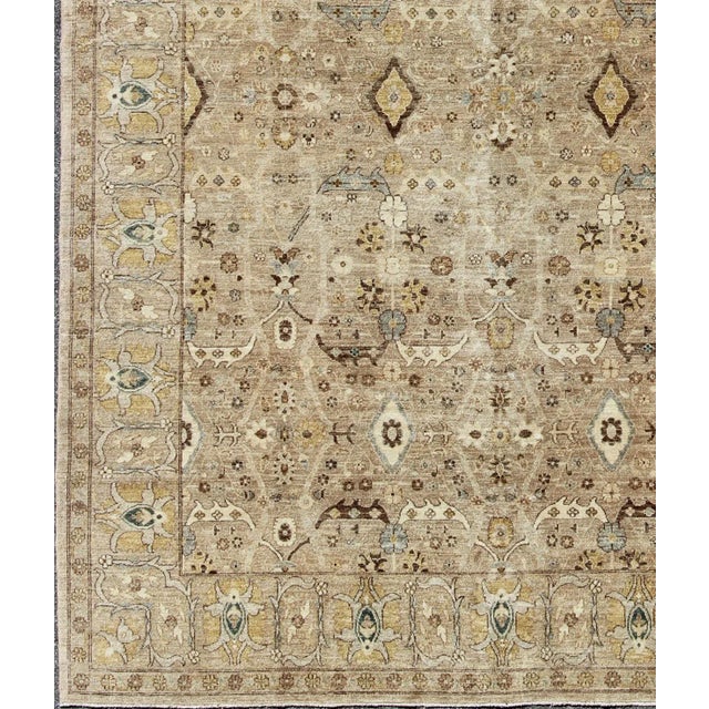 Tabriz Design rug with light Camel Background, Light Brown, tan , Light Brown, Lt. Blue, Yellow, and neutral color palette...