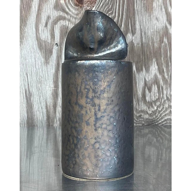 This late 20th-century studio pottery vase, with its unique "open can" design, embodies a minimalist Boho aesthetic. The...