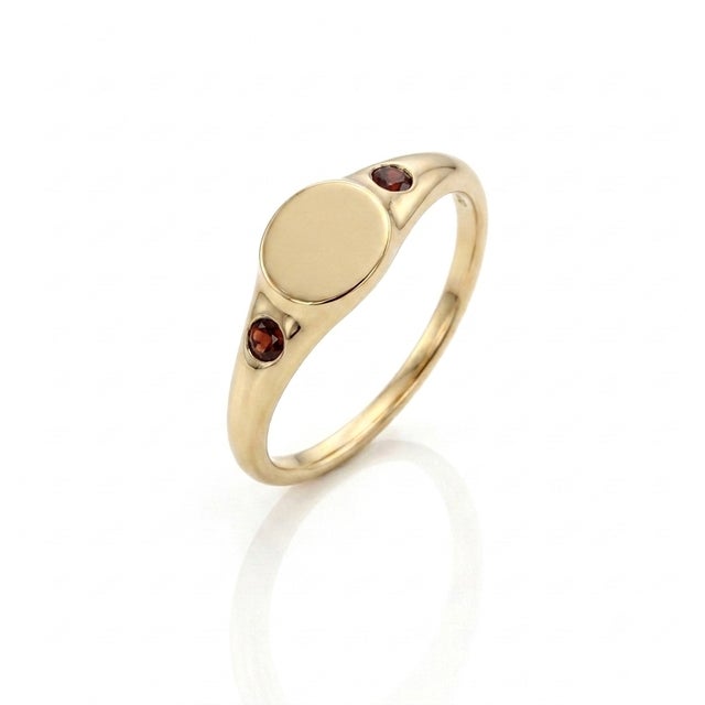 Timeless charm meets modern minimalism. This sophisticated signet ring highlights a glossy, blank oval center suited for...