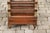 An English mahogany magazine rack on casters from the mid-20th century, with faux bamboo accents, two drawers and brass...