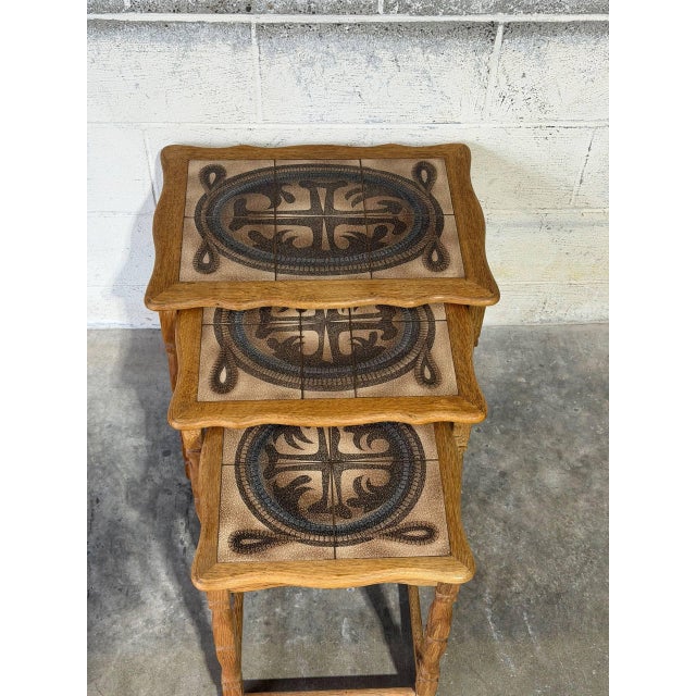 This set of three nesting tables features a convenient space-saving design. Each piece showcases striking ceramic tile...