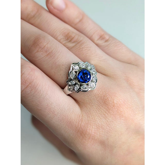 A Ceylon sapphire shines in a bright cornflower blue at the centre of this solid 14K white gold ring, surrounded by twelve...