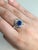 A Ceylon sapphire shines in a bright cornflower blue at the centre of this solid 14K white gold ring, surrounded by twelve...