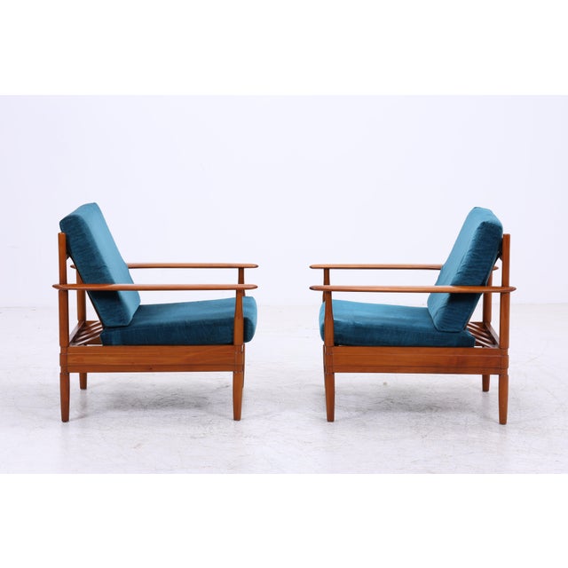 Vintage teak armchair by Grete Jalk with a sleek, open design and petrol-blue upholstery. The long armrests and the...