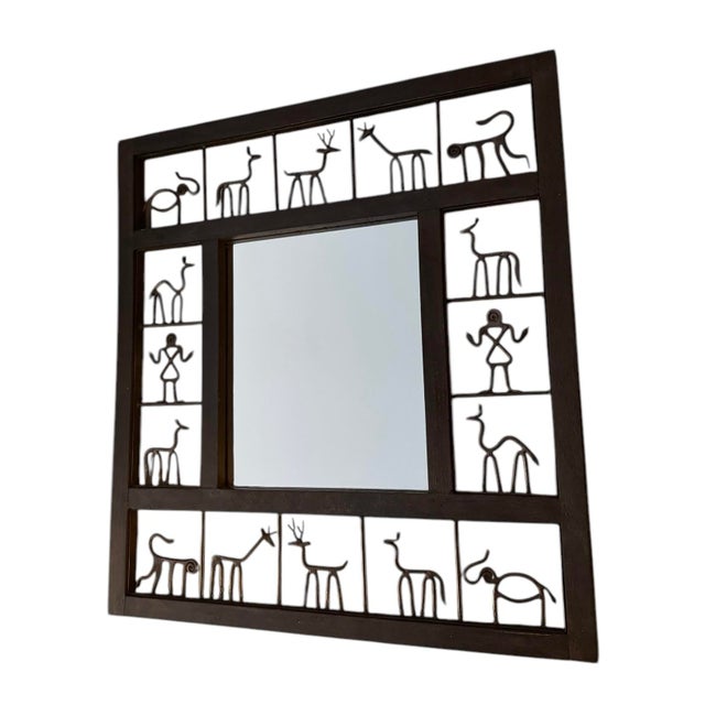 Beautiful vintage modern wall mirror in the style of Frederic Weinberg with handcrafted metalwork depicting primitive...