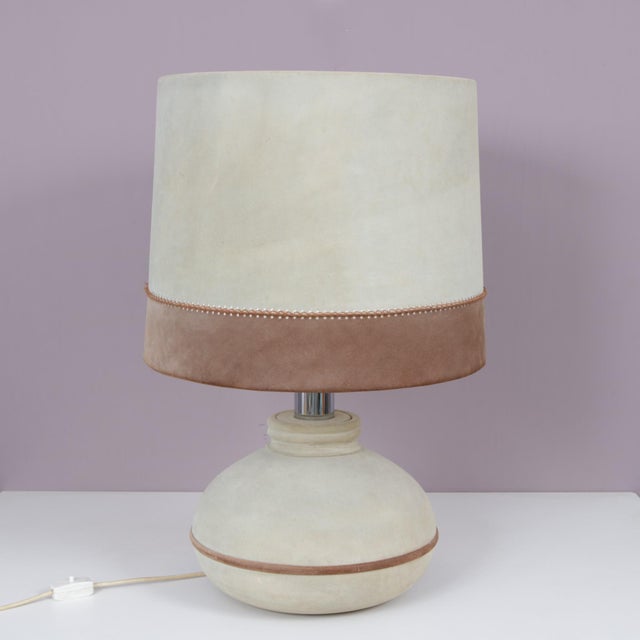 This striking 1970s French table lamp showcases a distinctive suede-upholstered base and hood, reflecting the era’s...