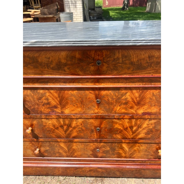 Showcasing stunning flame mahogany veneers with exceptional bookmatched grain, this 19th-century French Louis Philippe...