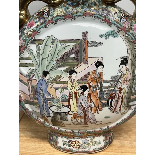 This is a vintage Chinese Famille Rose medallion shaped flask vase. It measures 18" tall and 12" wide across. It has gilt...