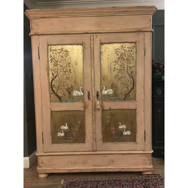 A beautiful antique double wardrobe featuring hand-painted chinoiserie panels by Trouvé Fine Art, with graceful swans,...