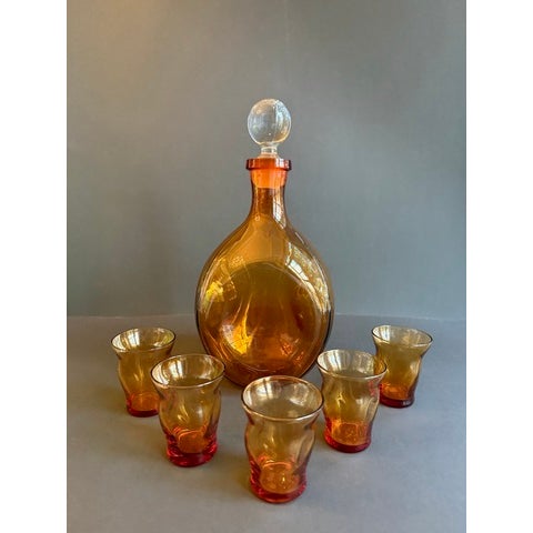 Elevate your home bar with this stunning hand-blown glass decanter set, featuring five exquisite shot glasses, all in a...