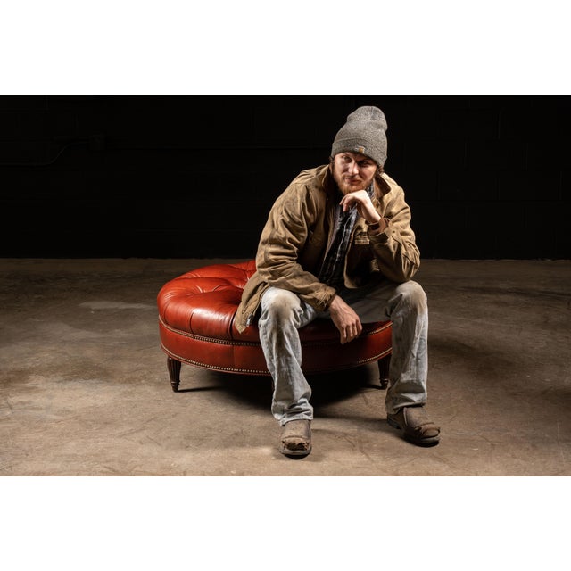 Vintage Tufted Ottoman in red. 42" in diameter. 18" in height. This vintage tufted ottoman features a deep rich red color....