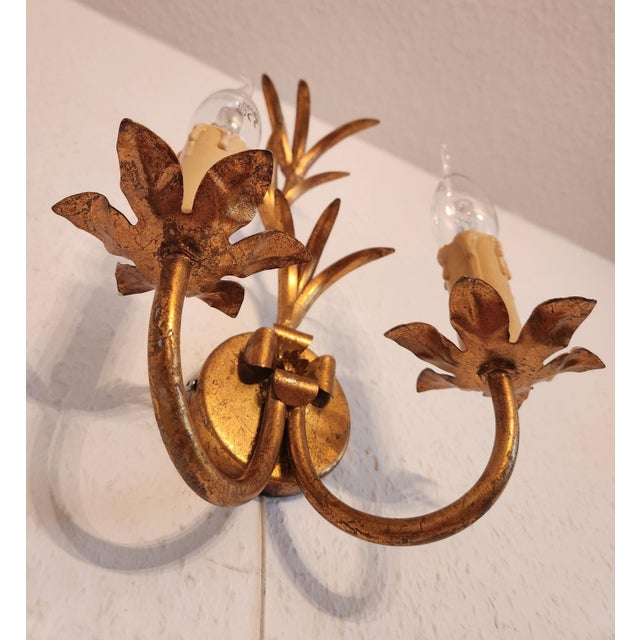 Highly decorative, hand-forged italian vintage florentine wall lamps, gilded in gold leaf with intricate floral and leaf...