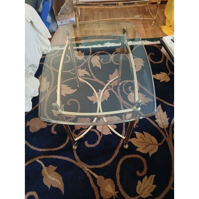 Vintage 1970s brass side table with glass top. Glass is very thick 3/8" with profile edge. Polished brass base. Attributed...