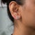 These solid 14K yellow gold earrings frame two montana sapphire stones in trillion cut, 1.01 carats in total, with thirty-...