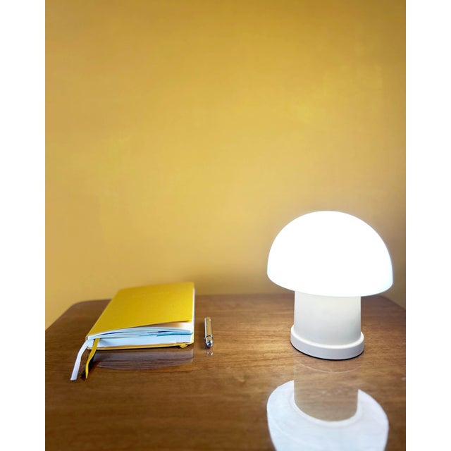 A small, vintage mushroom lamp with a delightfully seventies look, featuring an opaline glass globe and a white plastic...